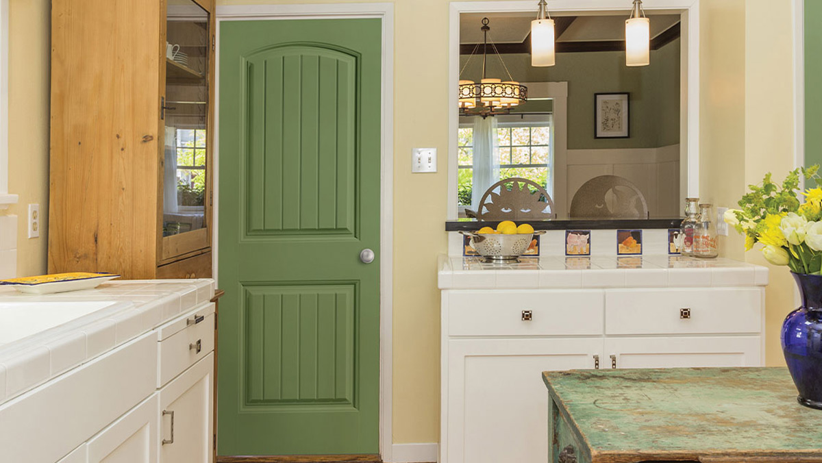 Kitchen with a green arch top 2 plank panel interior door