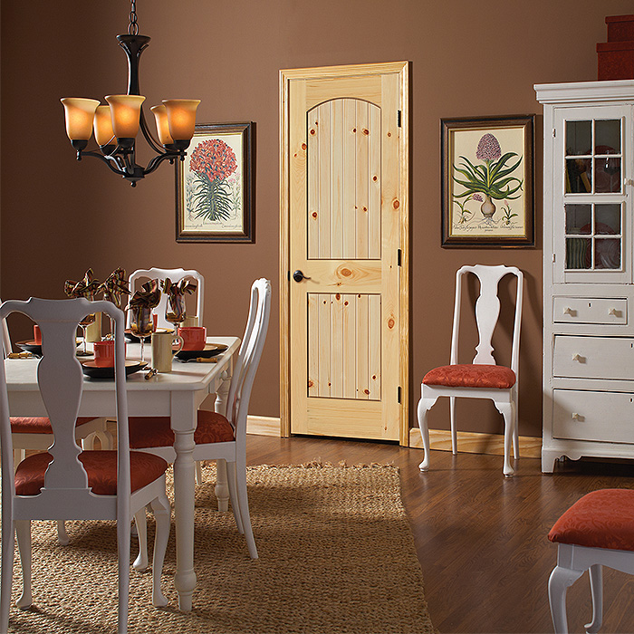 Knotty pine arch top 2 plank panel door in a traditional style dining room