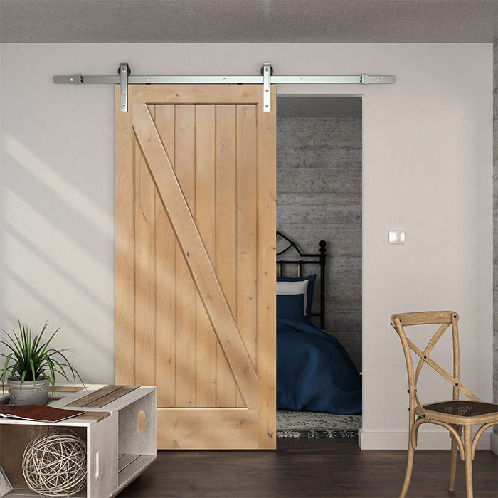 Wood barn door on a stainless steel track for a bedroom