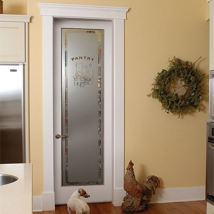 Decorative glass pantry door in a yellow kitchen with a stainless steel refrigerator and countertop to the left and green wreath on the wall to the right, rooster figurine on the floor, and a small dog in front of the pantry door