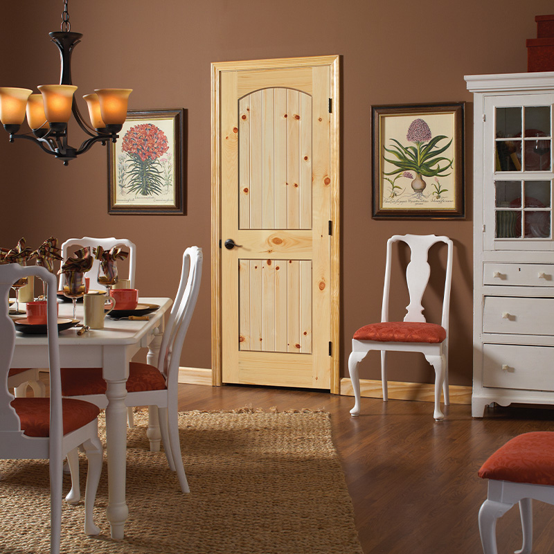 Dining room with a knotty pine 2 Panel arch top V-Groove interior door