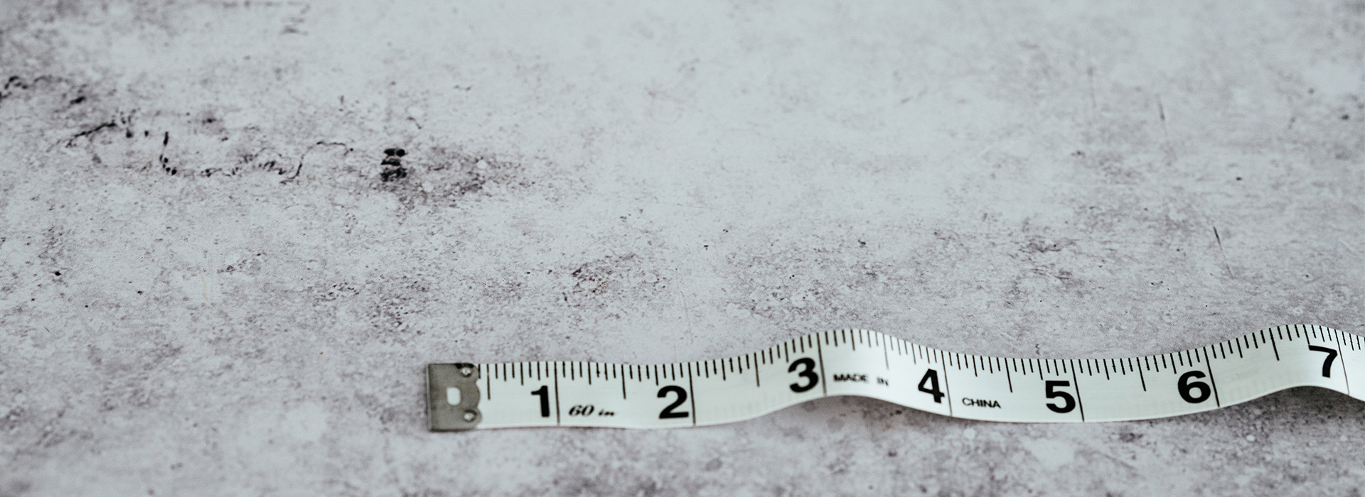 White loose measuring tape stretched out to 7 inches on marbled surface