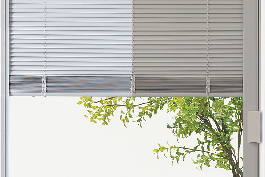 Half white colored mini blinds and half almond colored min blinds