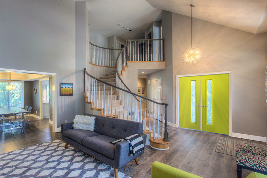 Modern living room with a grand staircase and 1 lite lime green double doors