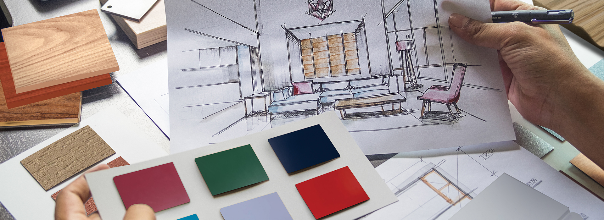 Close-up of a person holding pre-finish color samples in their left hand and and paper sketch of a modern living room in their right