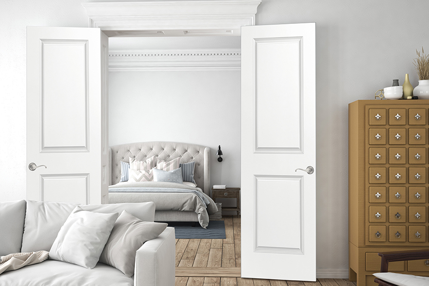 Greek Revival style living area with 2 panel white double doors leading to the bedroom