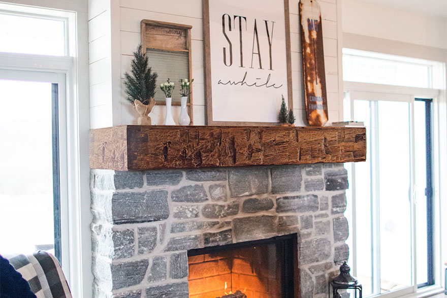 Stone fireplace with a wood grained beam mantel in a Modern Cottage living room