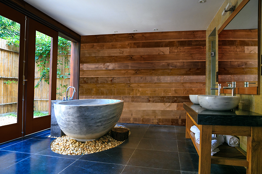 Modern cabin bathroom with a round bathtub and Pakari accent wall