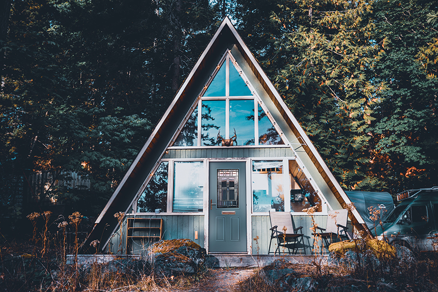 Triangular shaped cabin with a half lite 2 panel door in the woods